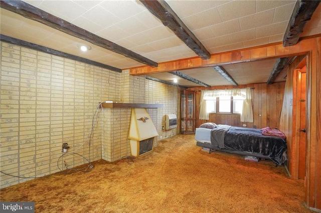 carpeted bedroom with beam ceiling, heating unit, and wooden walls