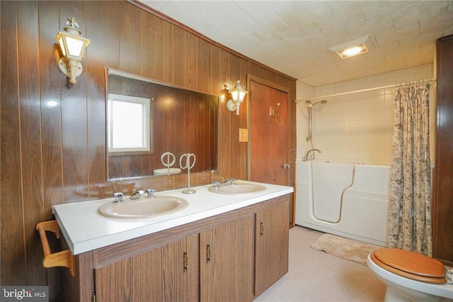 full bathroom with shower / bath combo, vanity, toilet, and wooden walls