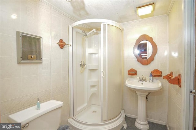 bathroom featuring crown molding, a shower with shower door, tile walls, and toilet