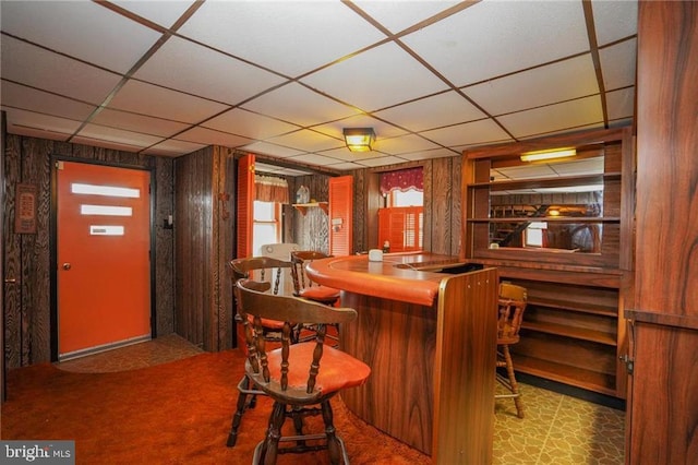 bar featuring carpet, a paneled ceiling, white refrigerator, and wood walls