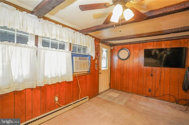 interior space featuring beamed ceiling, wood walls, light carpet, and a baseboard radiator