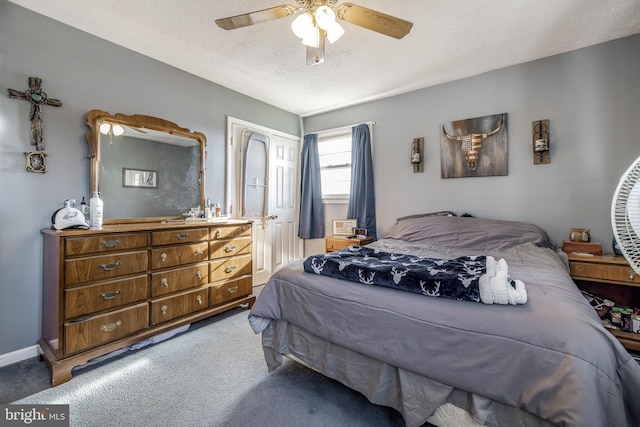 carpeted bedroom with ceiling fan and a textured ceiling