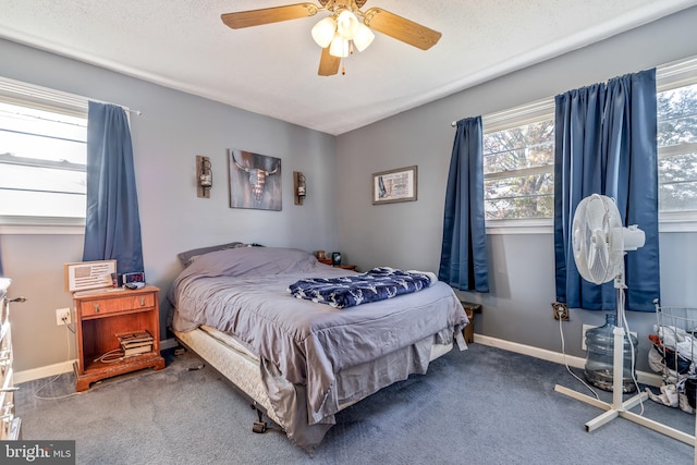 bedroom with multiple windows, ceiling fan, carpet floors, and a textured ceiling