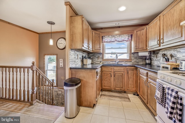 kitchen featuring crown molding, sink, a healthy amount of sunlight, and white stove