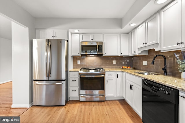 kitchen featuring white cabinets, stainless steel appliances, and light hardwood / wood-style floors