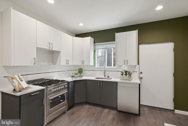 kitchen featuring stainless steel appliances, sink, wood-type flooring, white cabinets, and gray cabinets