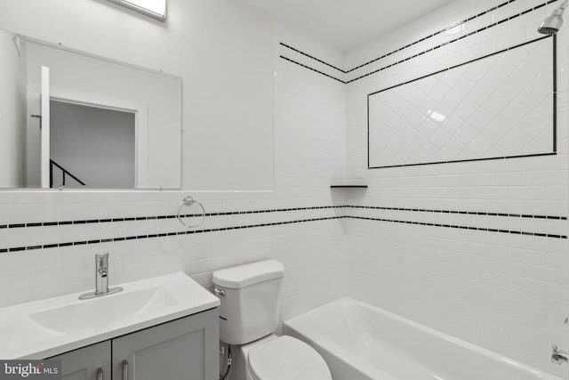 full bathroom with vanity, toilet, tile walls, and tiled shower / bath combo