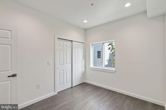 unfurnished bedroom featuring wood-type flooring and a closet