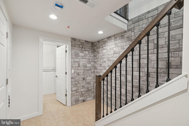 stairway featuring tile patterned floors and tile walls