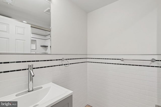 bathroom with vanity and tile walls