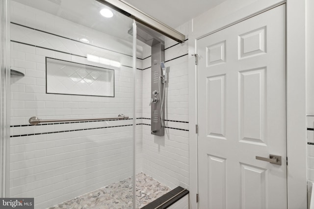 bathroom with a shower with door