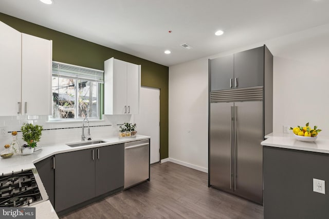 kitchen with white cabinets, dark hardwood / wood-style flooring, sink, and appliances with stainless steel finishes