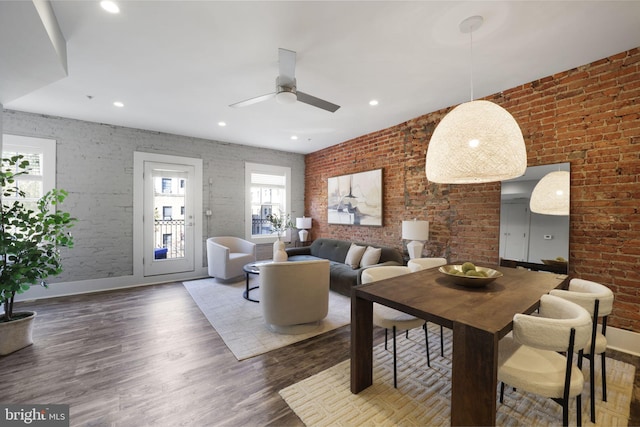 living room featuring ceiling fan, dark wood-type flooring, and brick wall