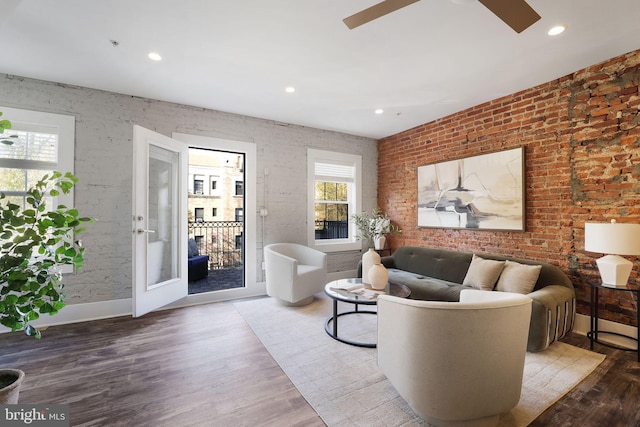 living room featuring hardwood / wood-style floors, french doors, and brick wall