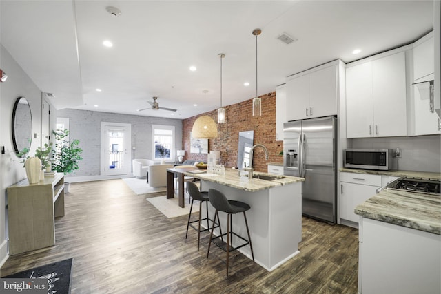 kitchen with white cabinets, sink, ceiling fan, appliances with stainless steel finishes, and decorative light fixtures