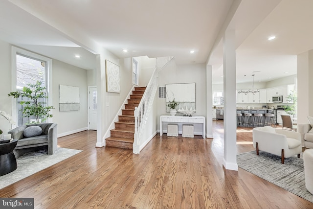 foyer with light hardwood / wood-style floors and a notable chandelier