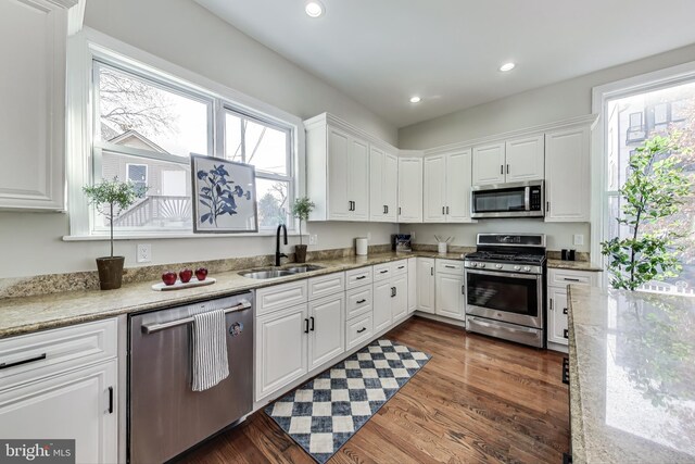 kitchen with a healthy amount of sunlight, sink, white cabinetry, and stainless steel appliances