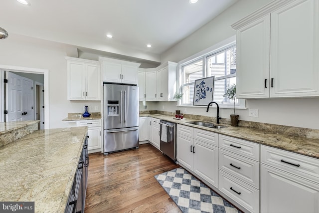 kitchen featuring stainless steel appliances, white cabinetry, and sink