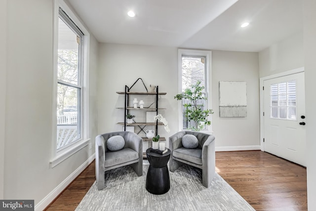 sitting room with a healthy amount of sunlight and dark wood-type flooring