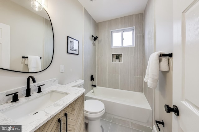 full bathroom featuring tile patterned flooring, vanity, toilet, and tiled shower / bath