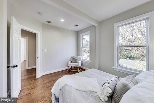 bedroom with hardwood / wood-style floors and multiple windows