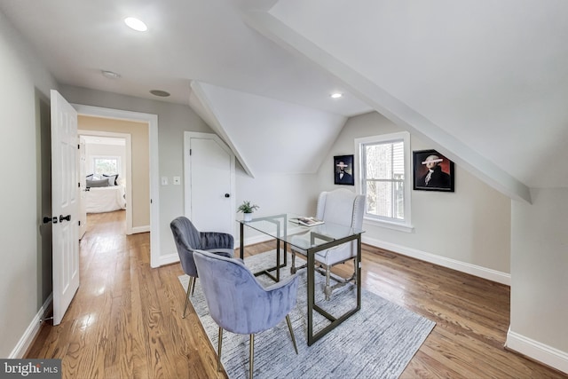 office space featuring light wood-type flooring and vaulted ceiling