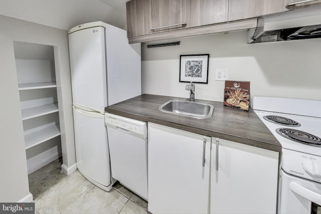 kitchen with white appliances, white cabinets, sink, light tile patterned floors, and extractor fan