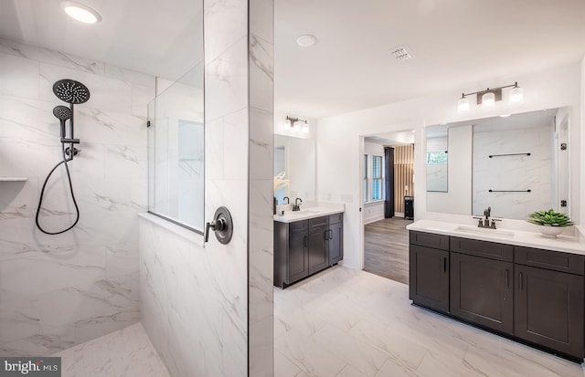 bathroom featuring a tile shower and vanity