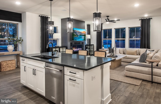 kitchen featuring sink, hanging light fixtures, dark hardwood / wood-style floors, an island with sink, and white cabinets