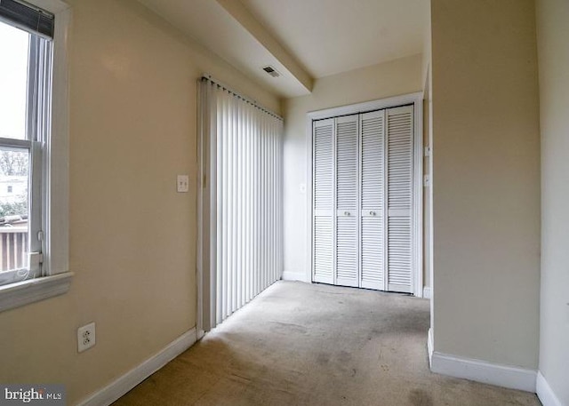 interior space featuring a closet and light colored carpet