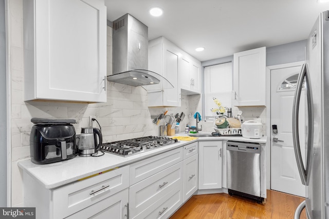 kitchen with white cabinetry, sink, wall chimney exhaust hood, and stainless steel appliances