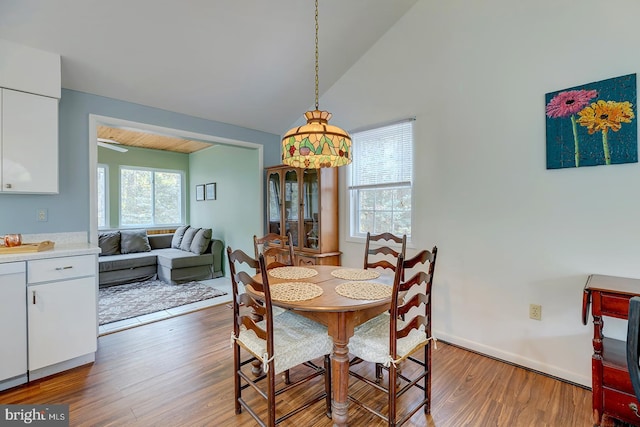 dining space with lofted ceiling and wood-type flooring