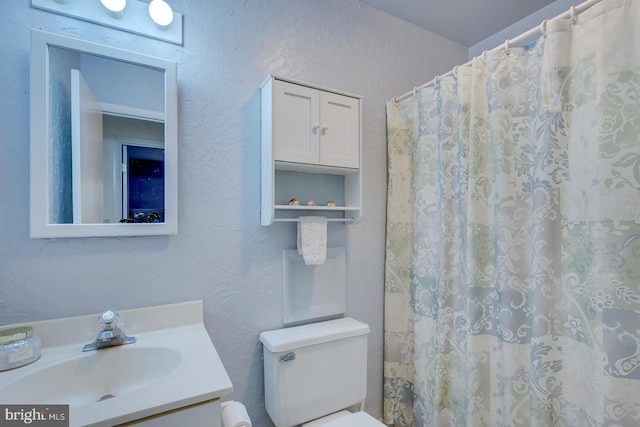 bathroom with vanity, toilet, and walk in shower