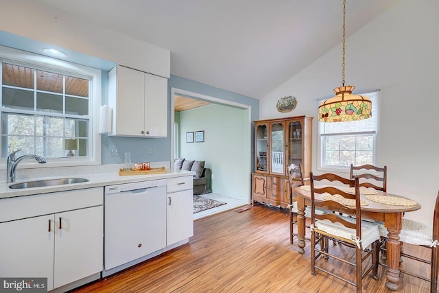 kitchen featuring sink, white dishwasher, vaulted ceiling, white cabinets, and light wood-type flooring