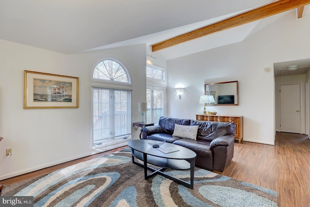 living room with lofted ceiling with beams and light hardwood / wood-style floors