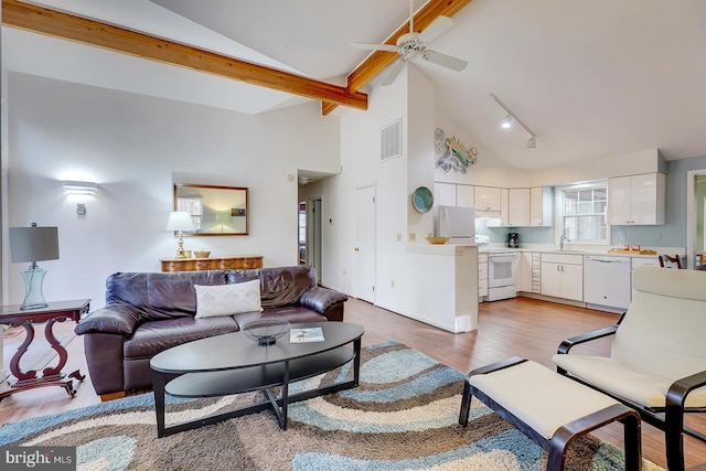 living room featuring high vaulted ceiling, sink, ceiling fan, beam ceiling, and light hardwood / wood-style floors