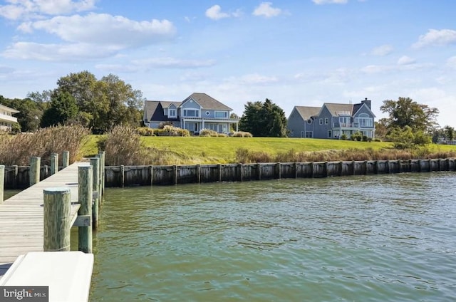 view of dock featuring a lawn and a water view