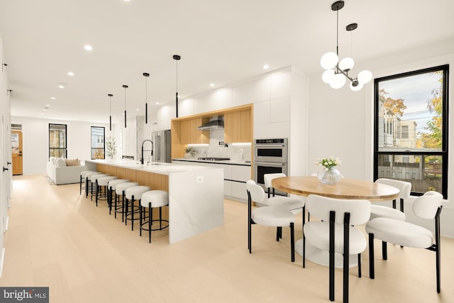 dining space with a wealth of natural light, a notable chandelier, and sink