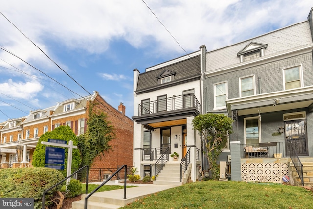 townhome / multi-family property with a porch and a front yard