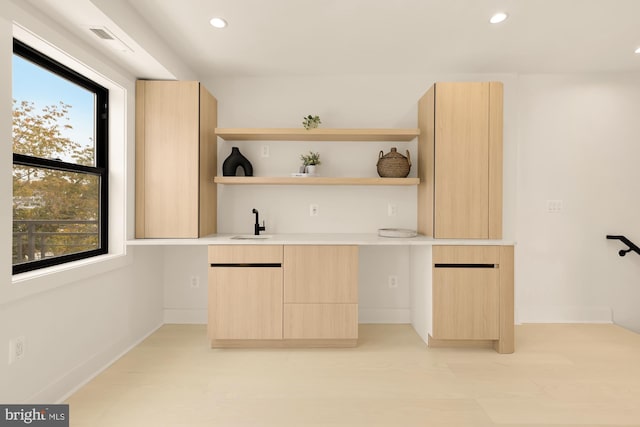 bar featuring sink and light brown cabinetry