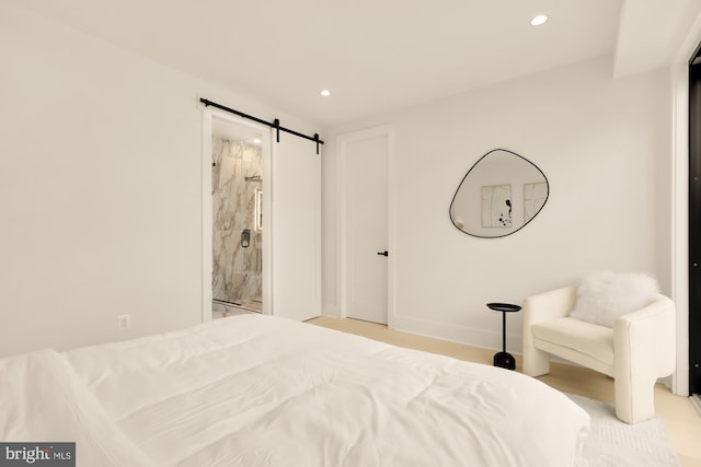 bedroom featuring ensuite bath and a barn door