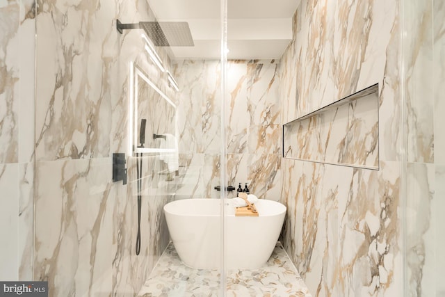 bathroom featuring shower with separate bathtub and tile walls