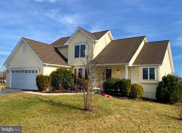 front facade featuring a garage and a front yard