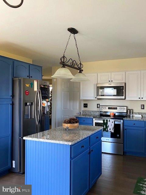 kitchen with white cabinetry, decorative light fixtures, stainless steel appliances, and blue cabinetry