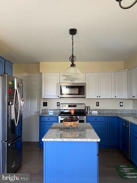 kitchen with stainless steel appliances, a center island, blue cabinets, and white cabinets