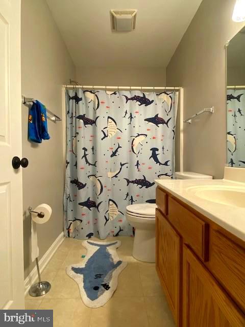 bathroom featuring a shower with curtain, vanity, toilet, and tile patterned flooring