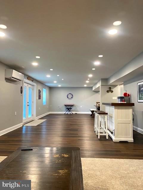 exercise room featuring bar area, dark hardwood / wood-style flooring, and an AC wall unit