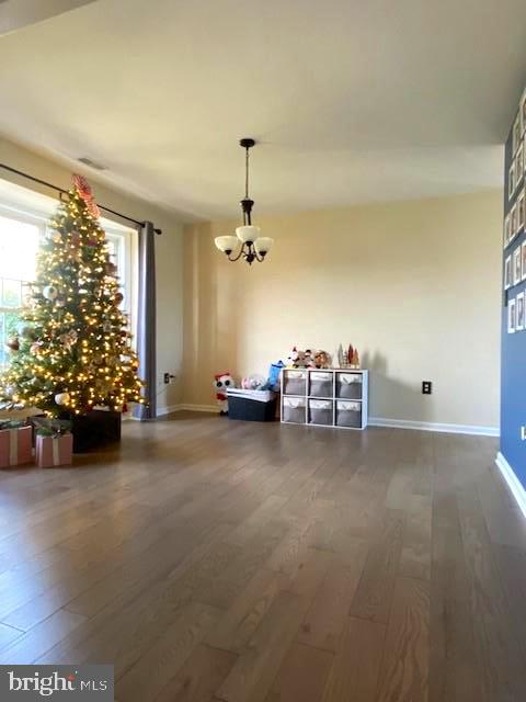 unfurnished dining area featuring hardwood / wood-style flooring and an inviting chandelier