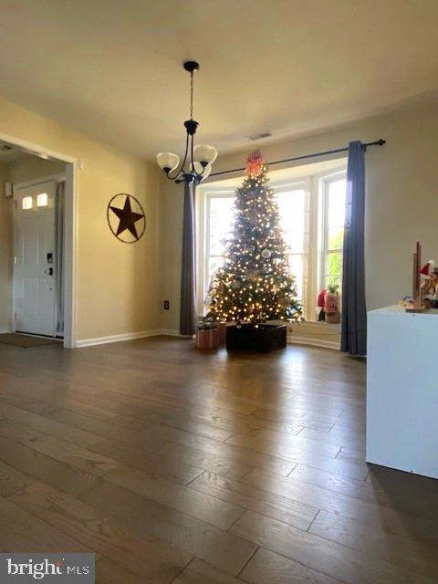 unfurnished dining area featuring dark hardwood / wood-style flooring and a notable chandelier