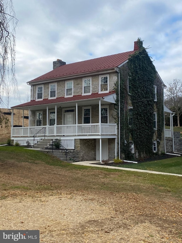 view of front of property featuring covered porch and a front yard